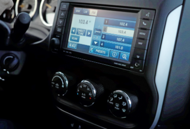 Car dashboard with touchscreen infotainment display and three climate control knobs
