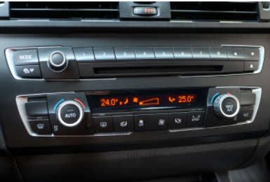 Car dashboard with digital climate control display and buttons, showing 24.0°C and 25.0°C settings