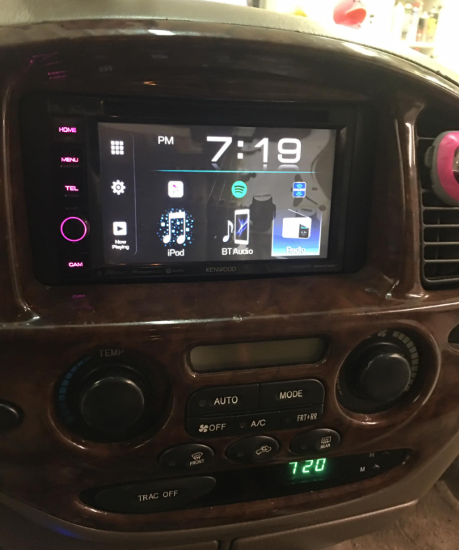 Car dashboard with lit touchscreen radio display showing 7:19 and climate controls below.