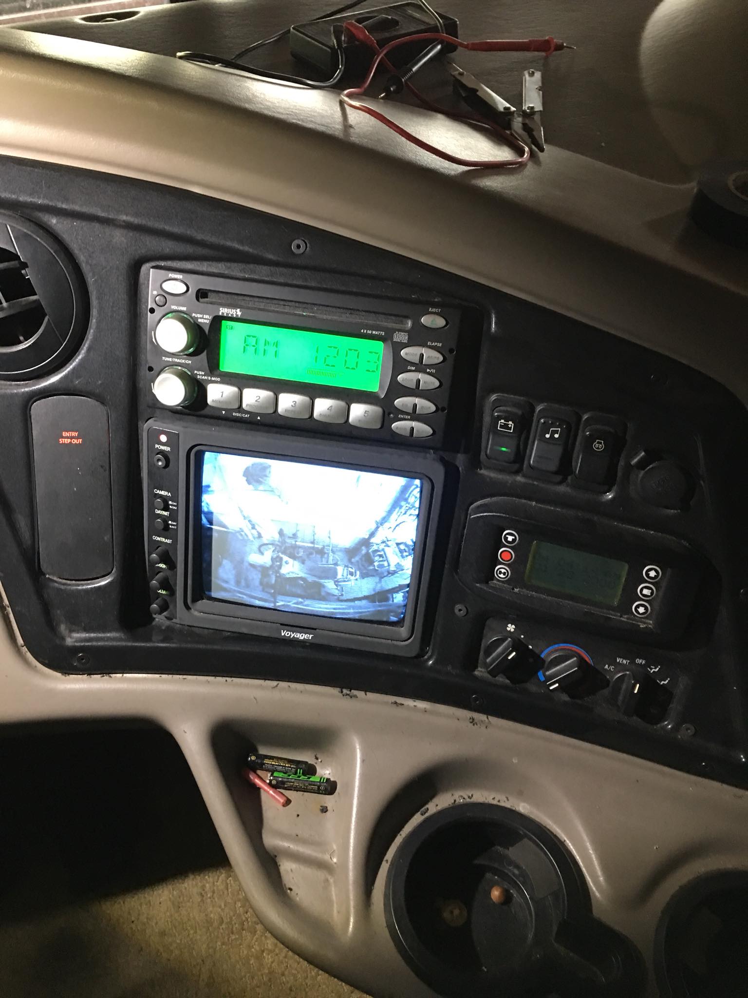 Car dashboard with stereo, touchscreen display, and control buttons on a dark interior panel