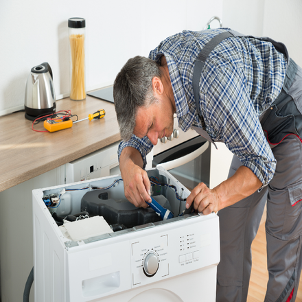 Repair Shop For Appliances — A Man Fixing The Range in Westerly, RI Repair Shop For Appliances — A Man Fixing The Range in Westerly, RI
