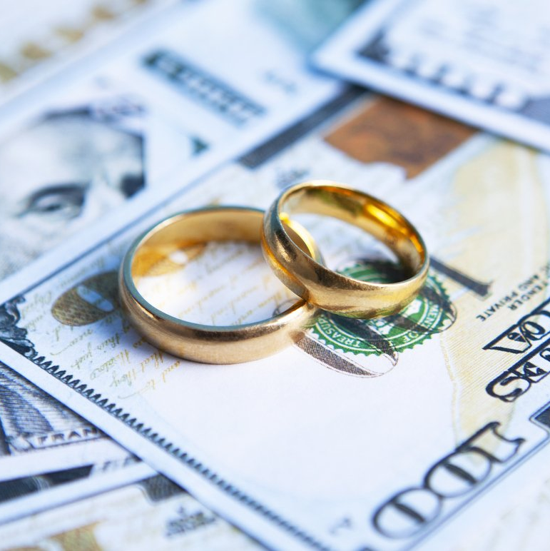 Do you have a high net worth divorce about to happen? Call us today! Two golden rings signifying marriage on top of money about to go through a divorce