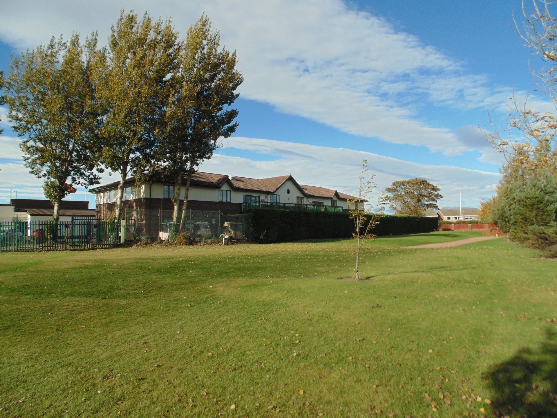 A lush green field with a house in the background