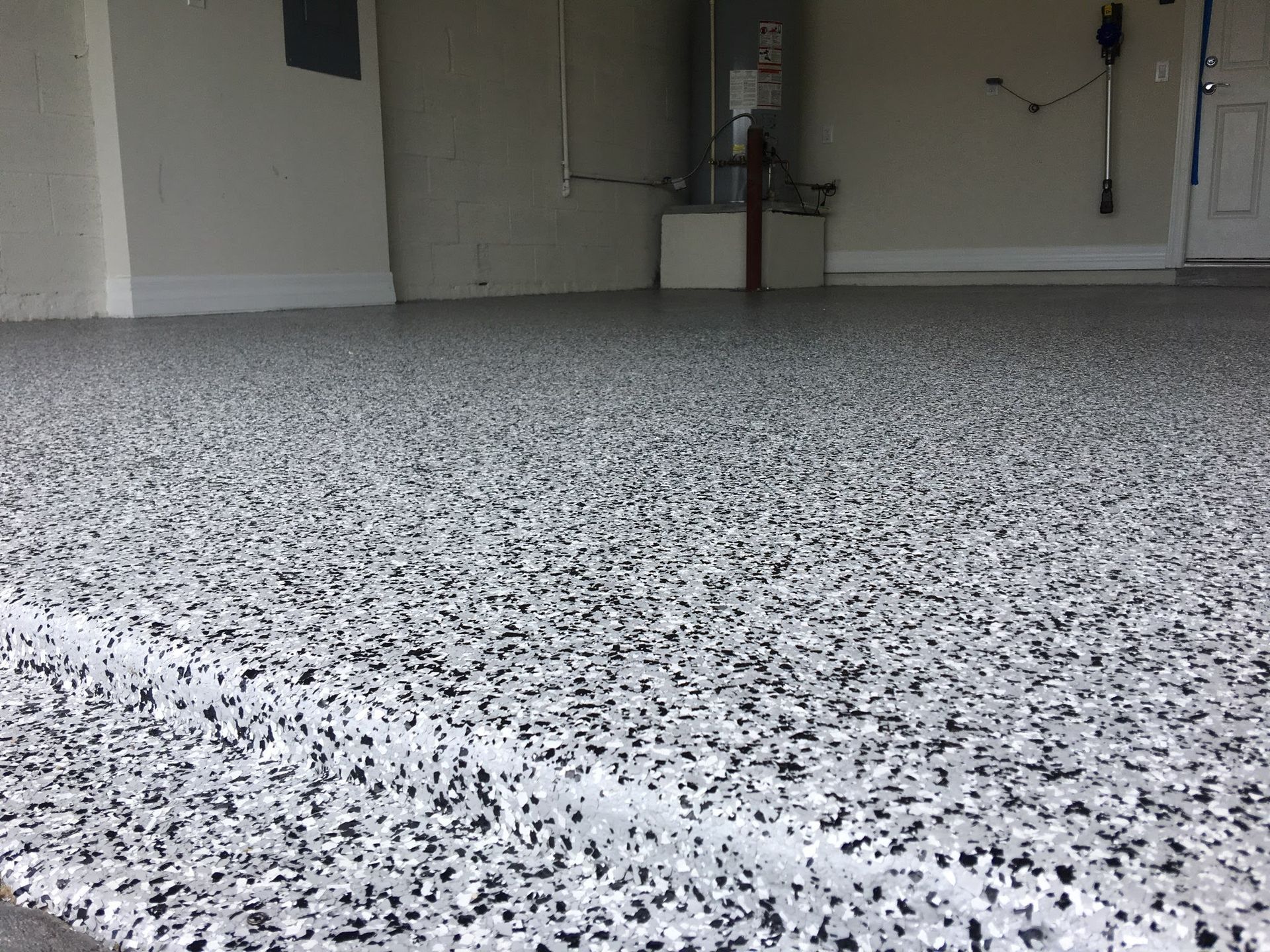 Speckled gray epoxy floor in an empty garage or basement room