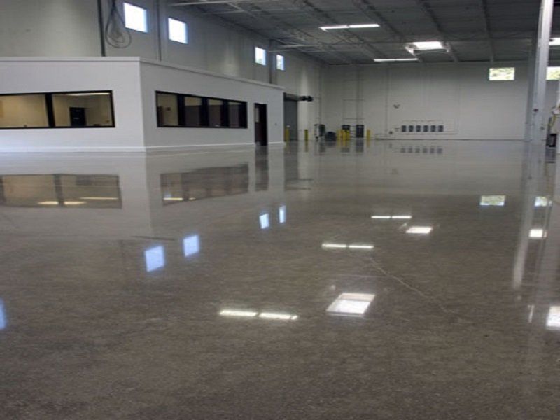Empty polished warehouse interior with glossy concrete floor and white walls