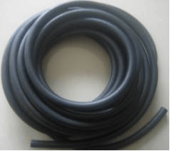a roll of black rubber hose is sitting on a table .