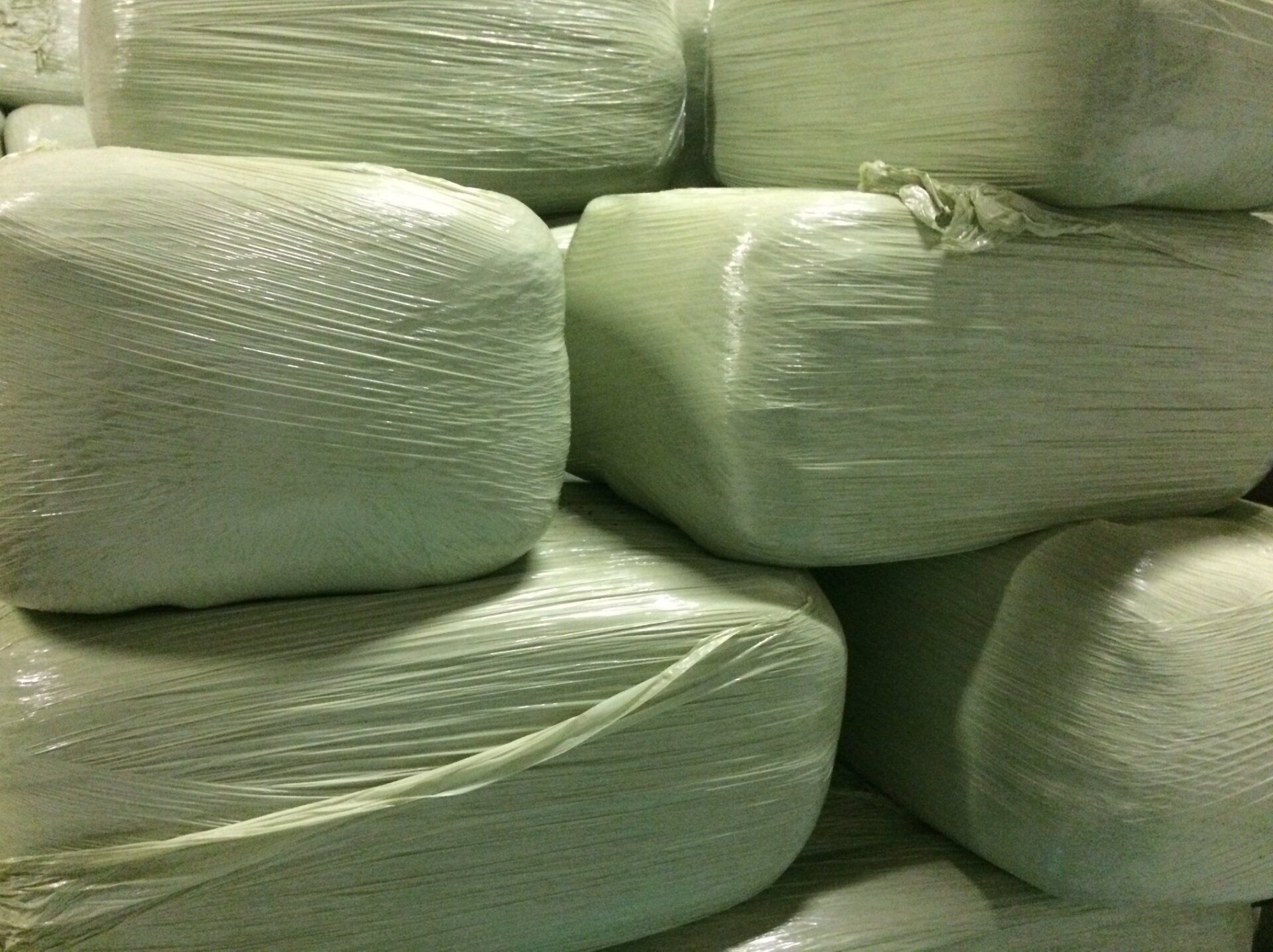 a bunch of white bags wrapped in plastic are stacked on top of each other