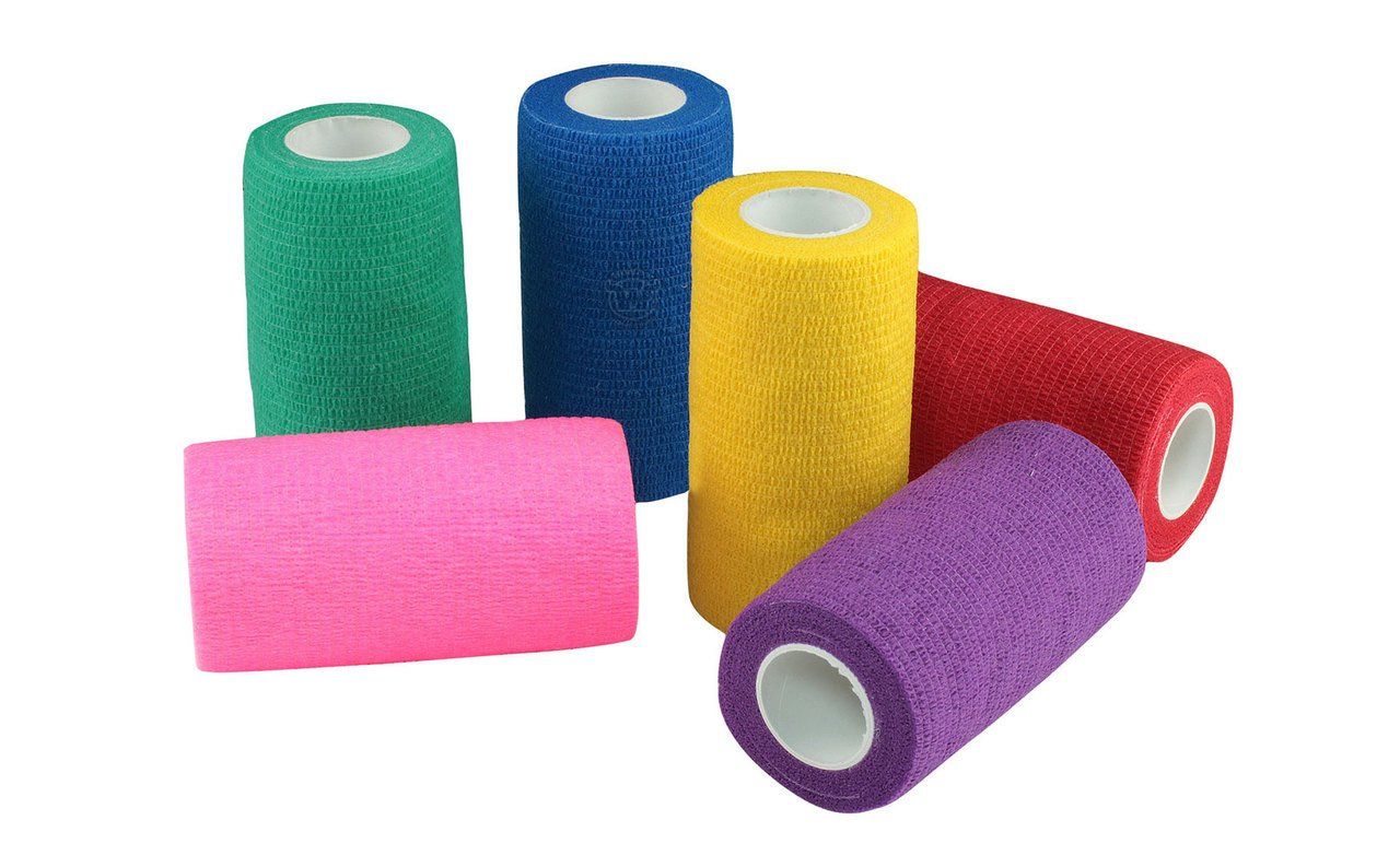 several rolls of bandages of different colors are stacked on top of each other