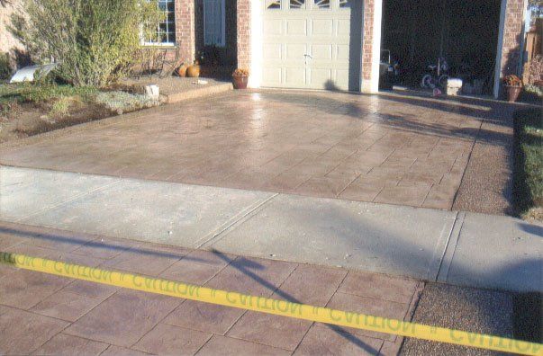 A concrete driveway with a yellow tape around it
