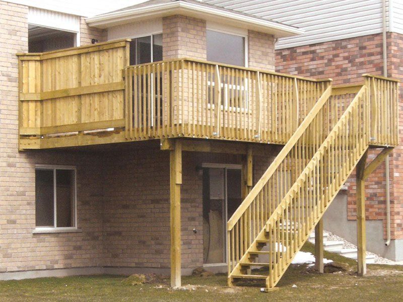 A brick house with a wooden deck and stairs