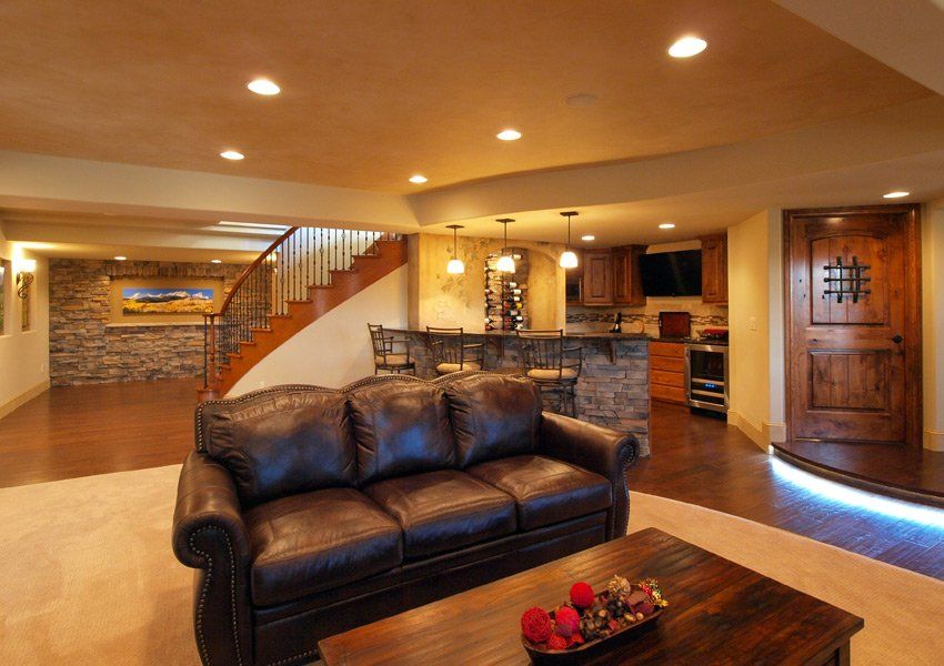 A living room with a brown leather couch and a wooden table.