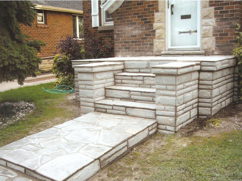 A stone walkway leading to the front door of a brick house