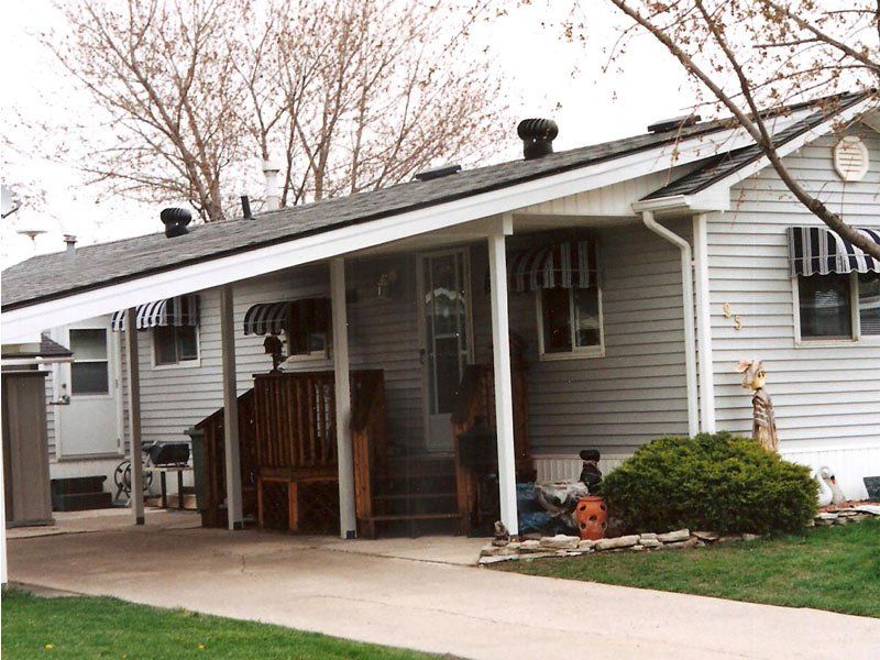 A house with a porch and awnings on the windows