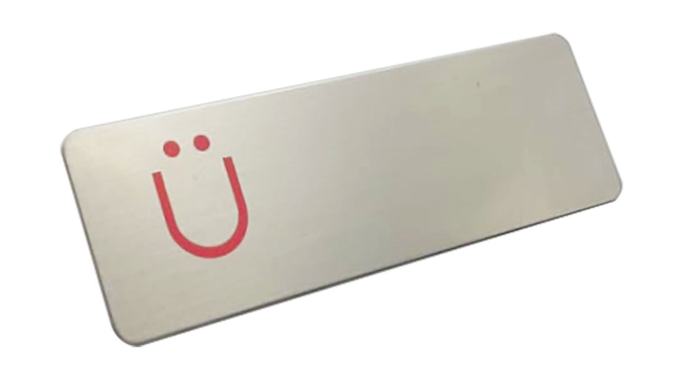 Placa de metal blanco con un logotipo de una cara sonriente roja.
