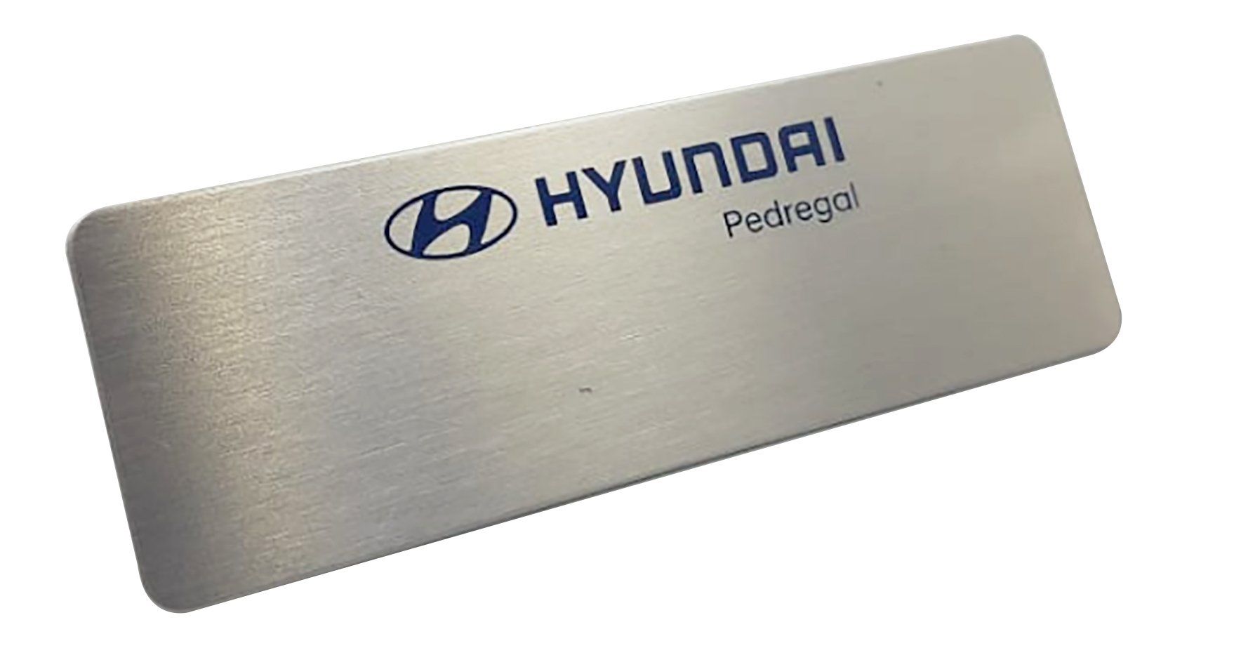 Placa de metal cepillado con la marca Hyundai, con logotipo y texto grabados sobre un fondo blanco.