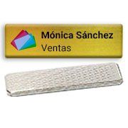 Placa identificativa para Mónica Sánchez, con la etiqueta “Ventas”, logotipo colorido y clip de plástico transparente.
