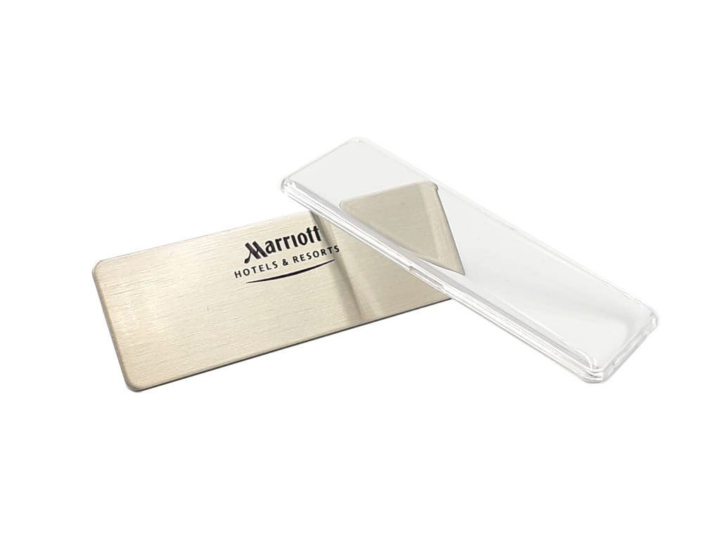 Dos tarjetas de crédito metálicas, una dorada y otra plateada, apiladas sobre un fondo blanco.