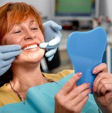 Dental Treatments — Patient Checking her Teeth in Warwick, RI Dental Treatments — Patient Checking her Teeth in Warwick, RI