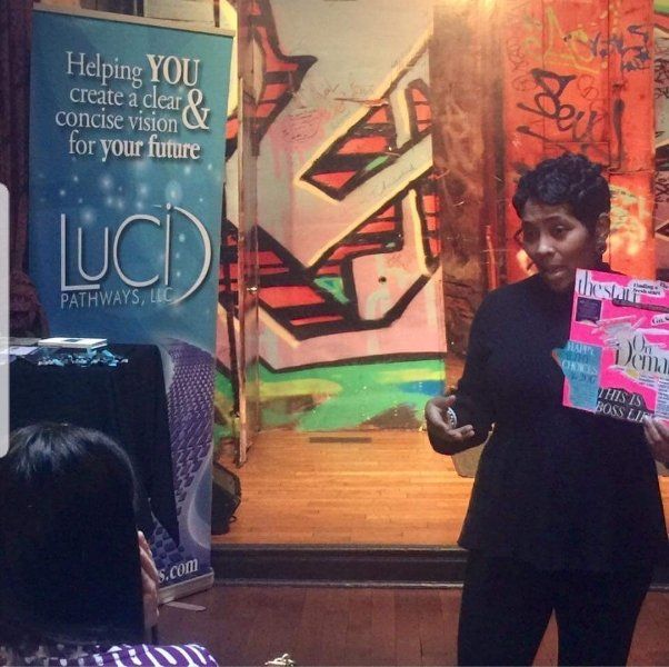 A woman stands in front of a sign that says luci