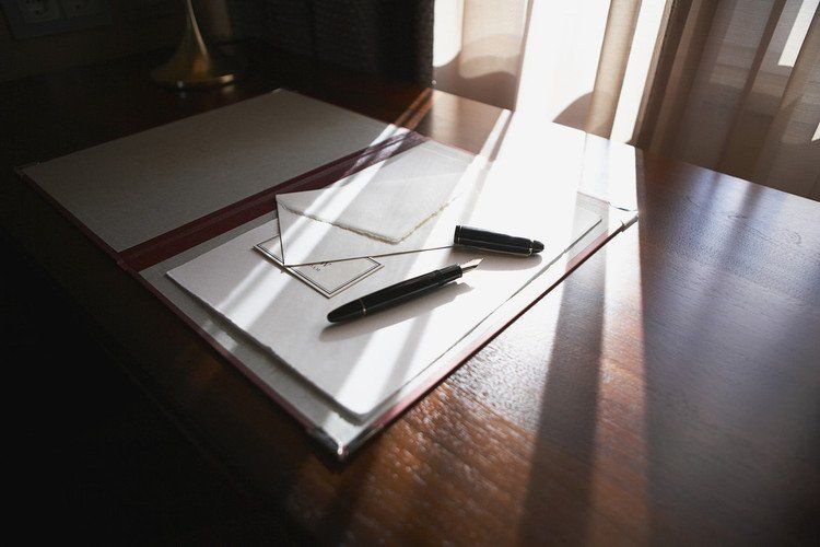 Ein Stift liegt auf einem Blatt Papier auf einem Tisch.