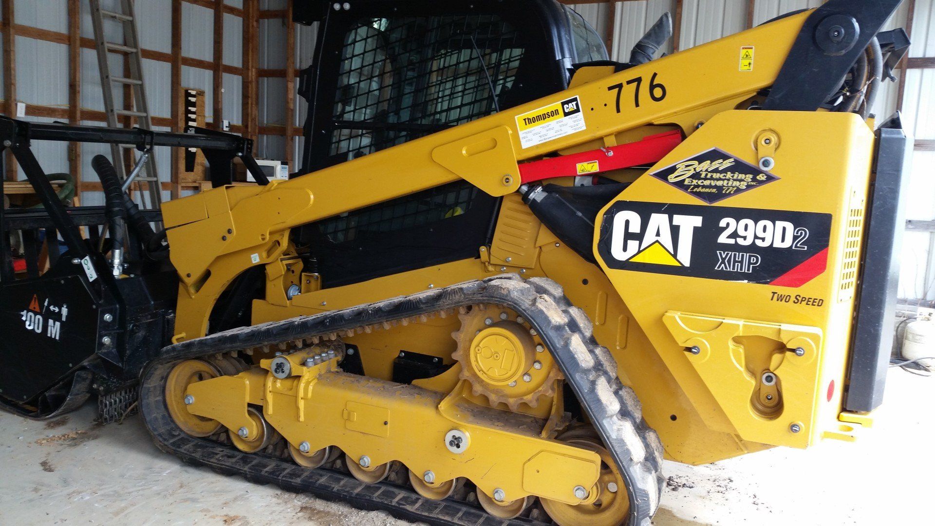 A cat 2990 skid steer is parked in a barn.
