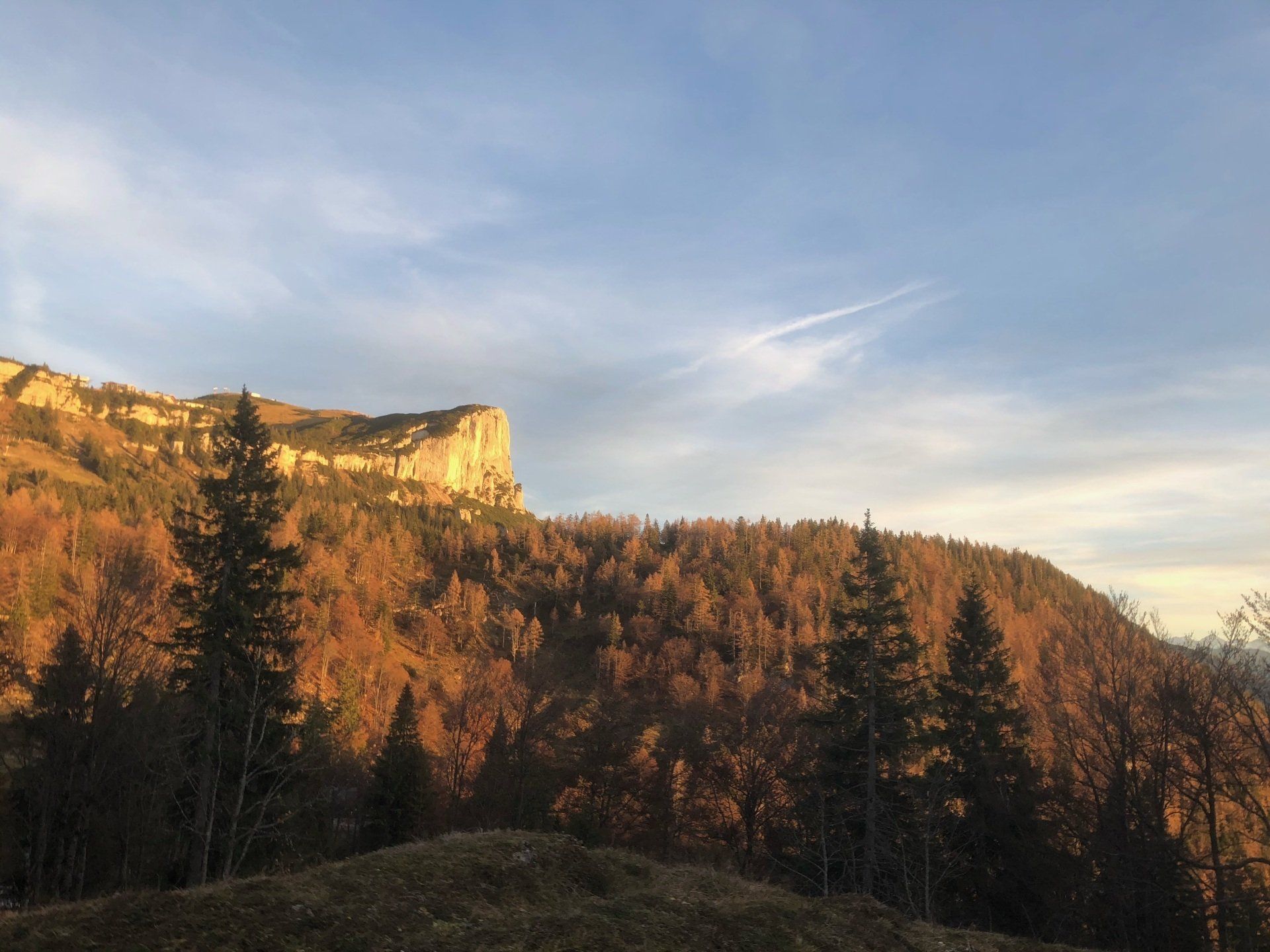 Sonnenbeschienener Herbstwald und Klippen unter einem klaren blauen Himmel