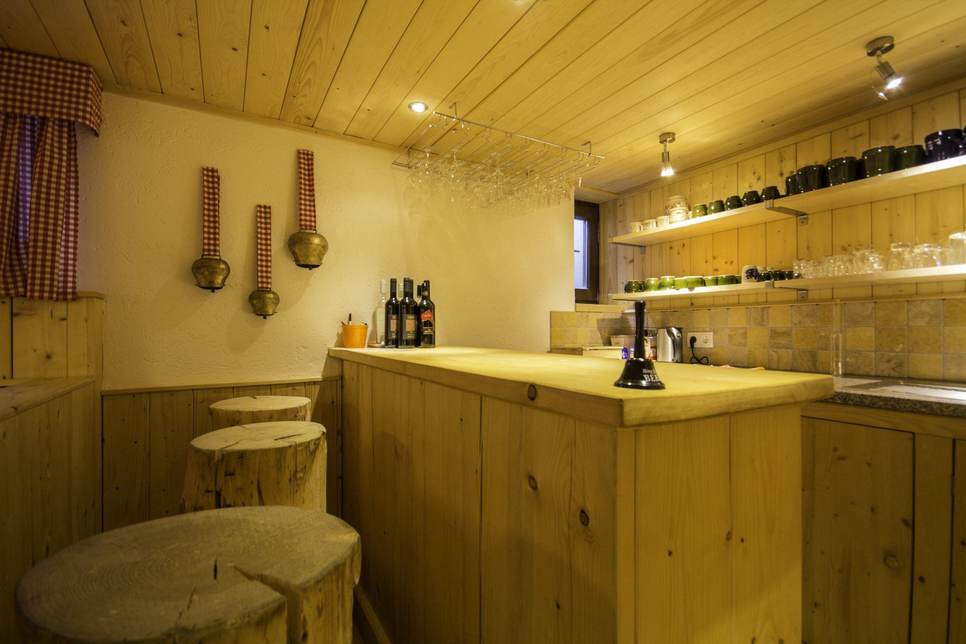 Rustikale Bar aus Holz mit Barhockern, Flaschenregalen und warmem Licht