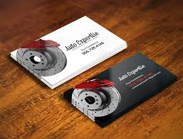 Business cards featuring a car brake design, stacked on a wooden surface, with a white and black color scheme.