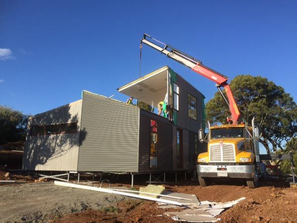 crane truck lifting part of a home