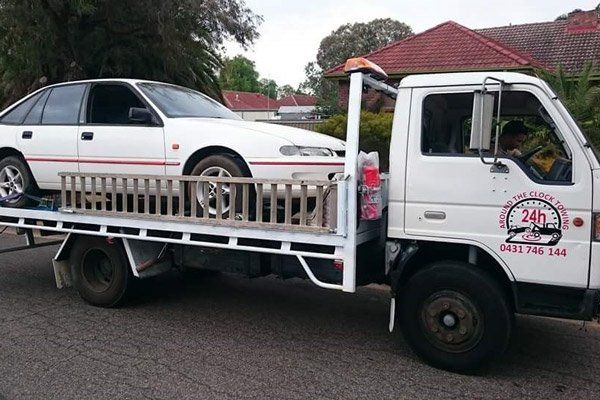 Around the Clock Towing truck towing white car around the clock towing truck towing white car