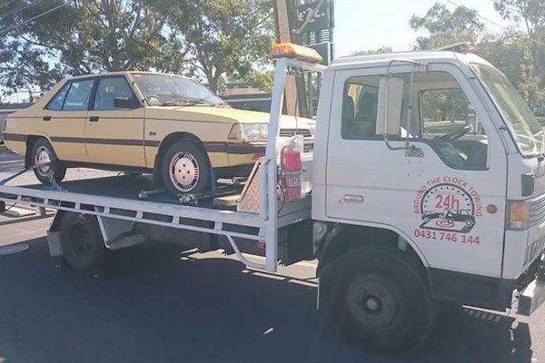 Around the Clock Towing truck towing yellow car around the clock towing truck towing yellow car