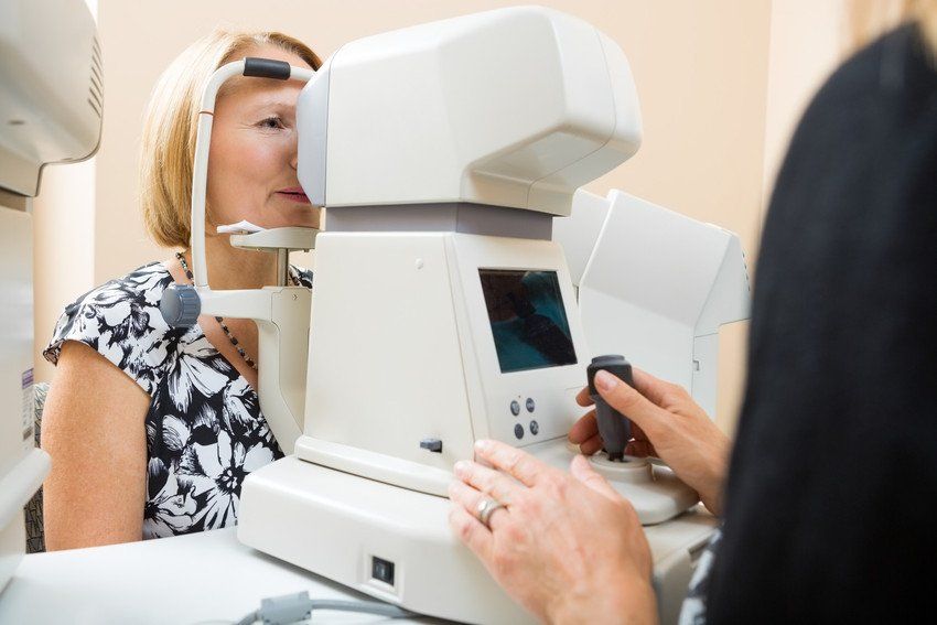 optician examining patient's eye pressure with tonometer