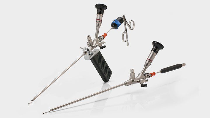 Two surgical instruments are sitting next to each other on a white surface.