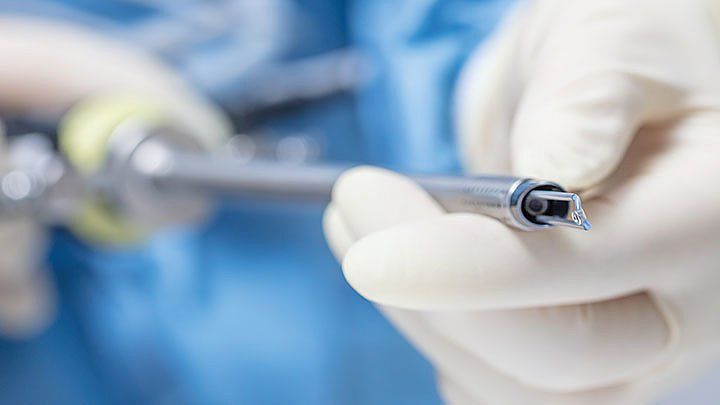 A close up of a person holding a screwdriver in their hand.