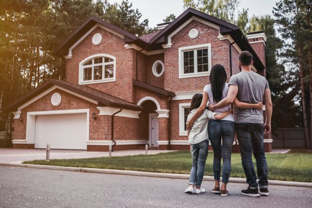 couple and their child happy looking at their new home