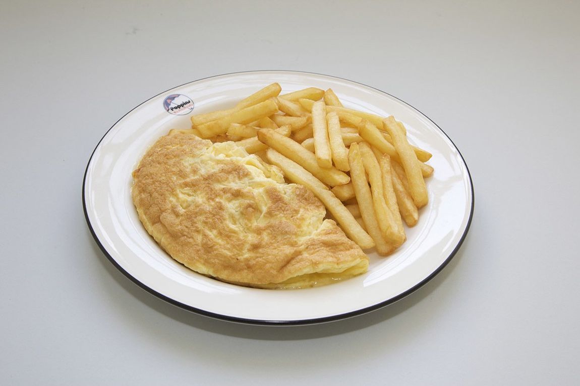 Omelet and fries on a white plate against a plain background