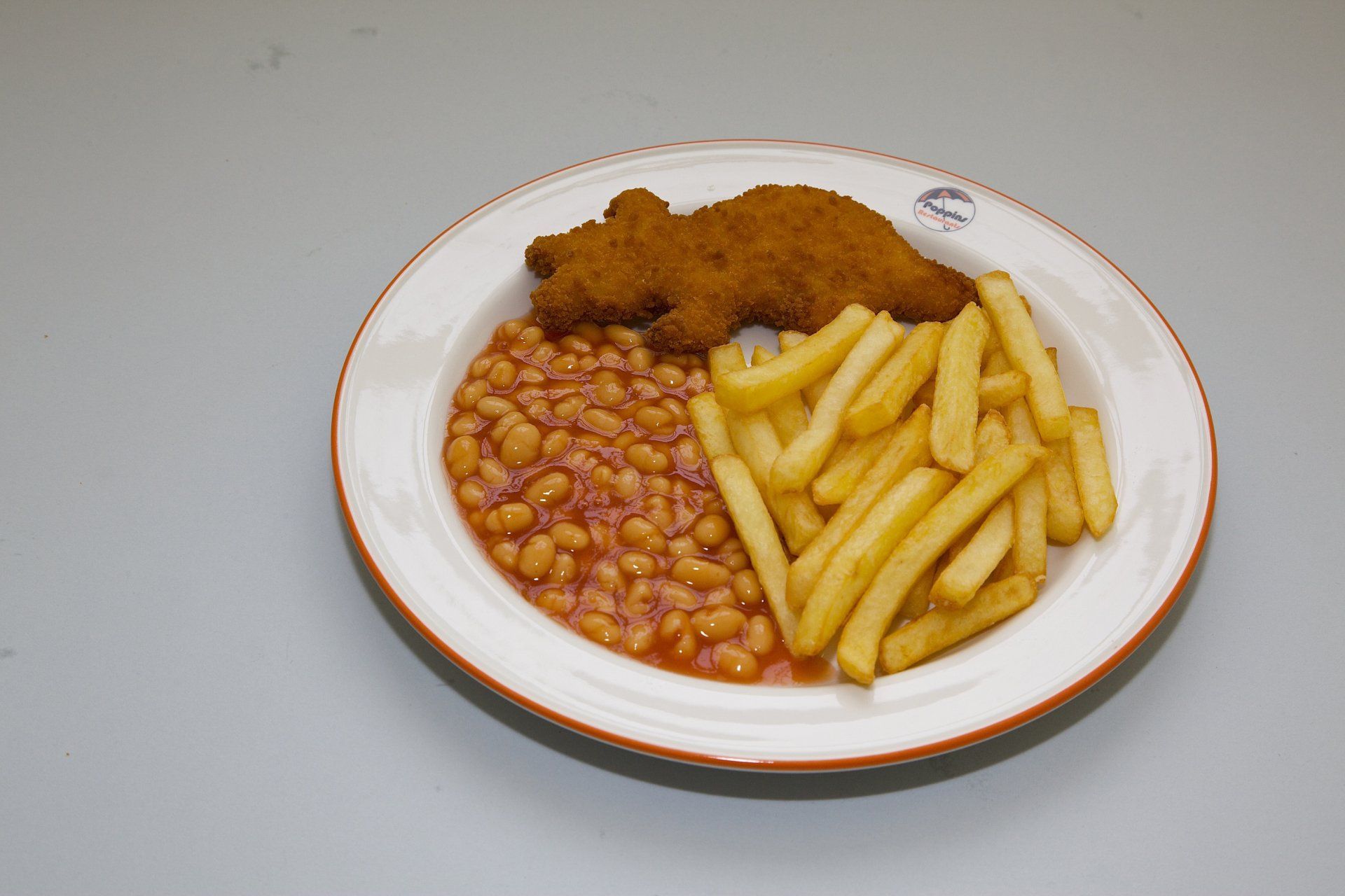 Plate with breaded fried fish, baked beans, and French fries on a white background