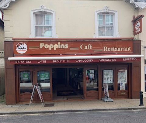 Poppins Café Restaurant storefront with brown awning and sidewalk signs