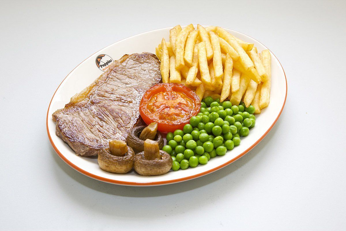 Plate with steak, fries, peas, tomatoes, and mushrooms on a white background