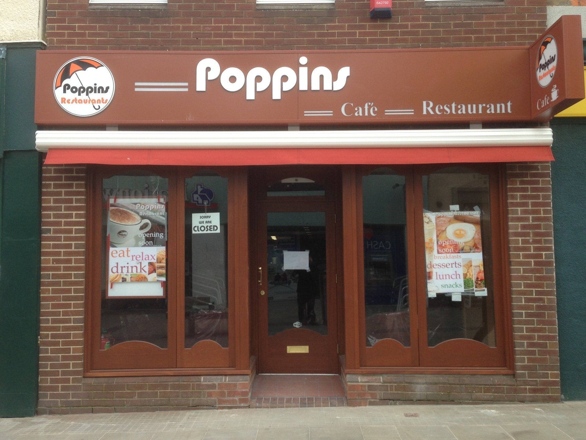 Poppin café and restaurant storefront with brown brick facade and glass doors