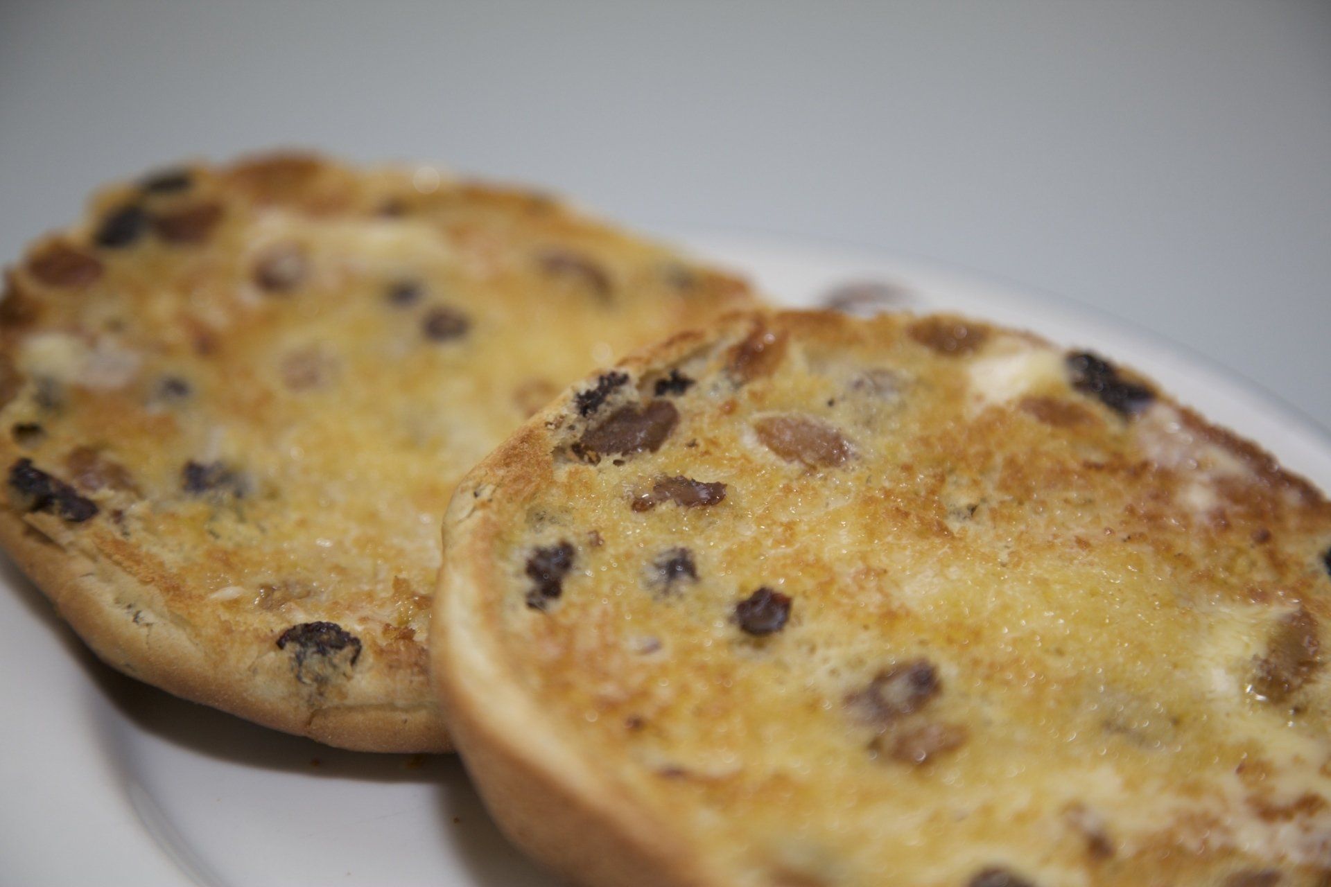 Two chocolate chip muffins on a white plate