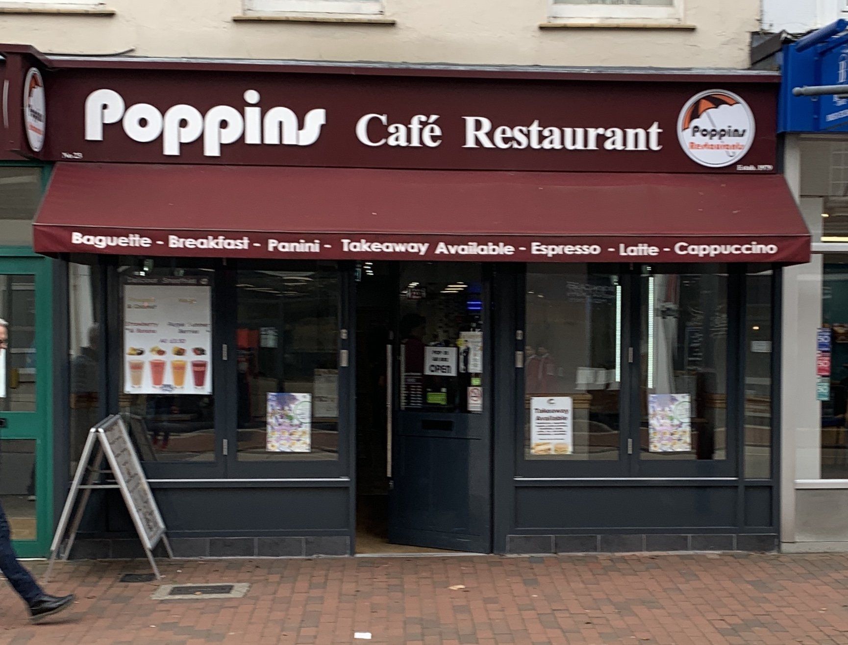 Poppins Café Restaurant storefront with maroon awning and sidewalk entrance
