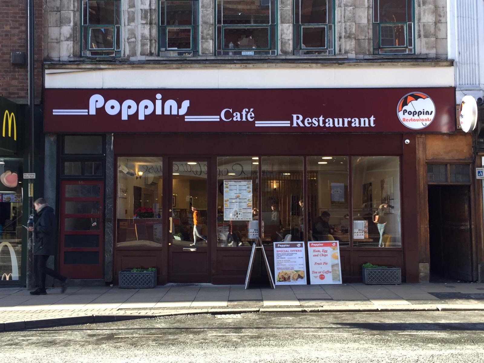 Poppin Café Restaurant storefront with burgundy awning and street-side menu boards