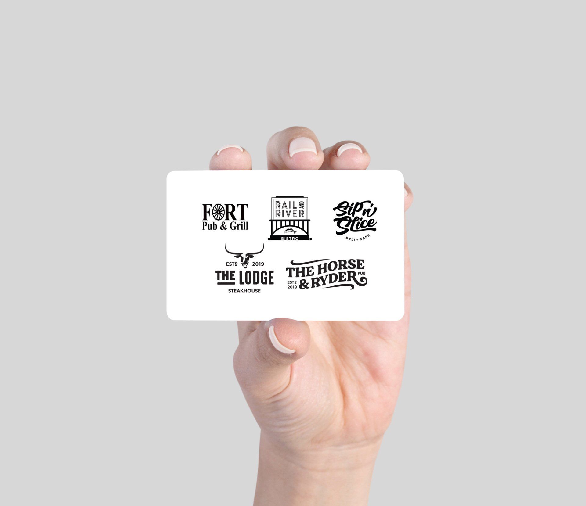 A hand is holding a business card that says fort and the lodge