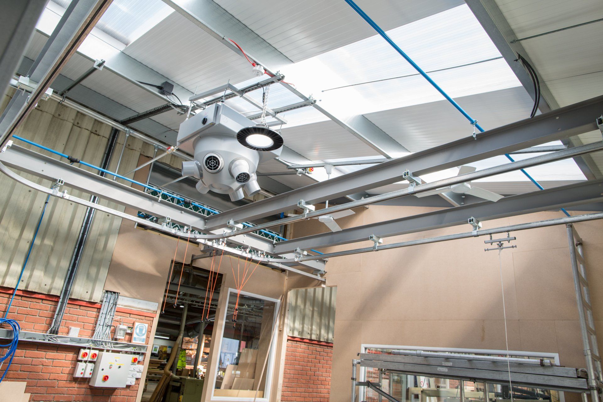 Overhead industrial system with mounted on a metal track in a warehouse setting.