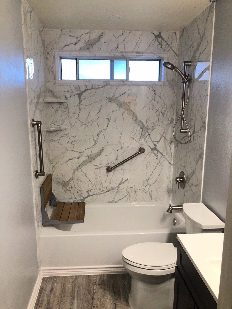 Calcutta Marble Wall Surround with White Bathtub Adjustable Shower Head Grab Bars and Foldable Seat