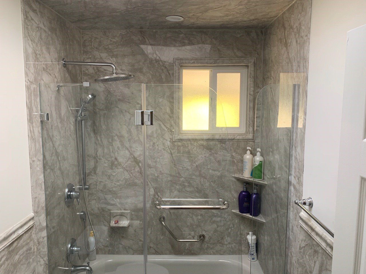 Pompeii Marble Shower Wall with White Tub Glass Door Grab Bar Rain Shower Head