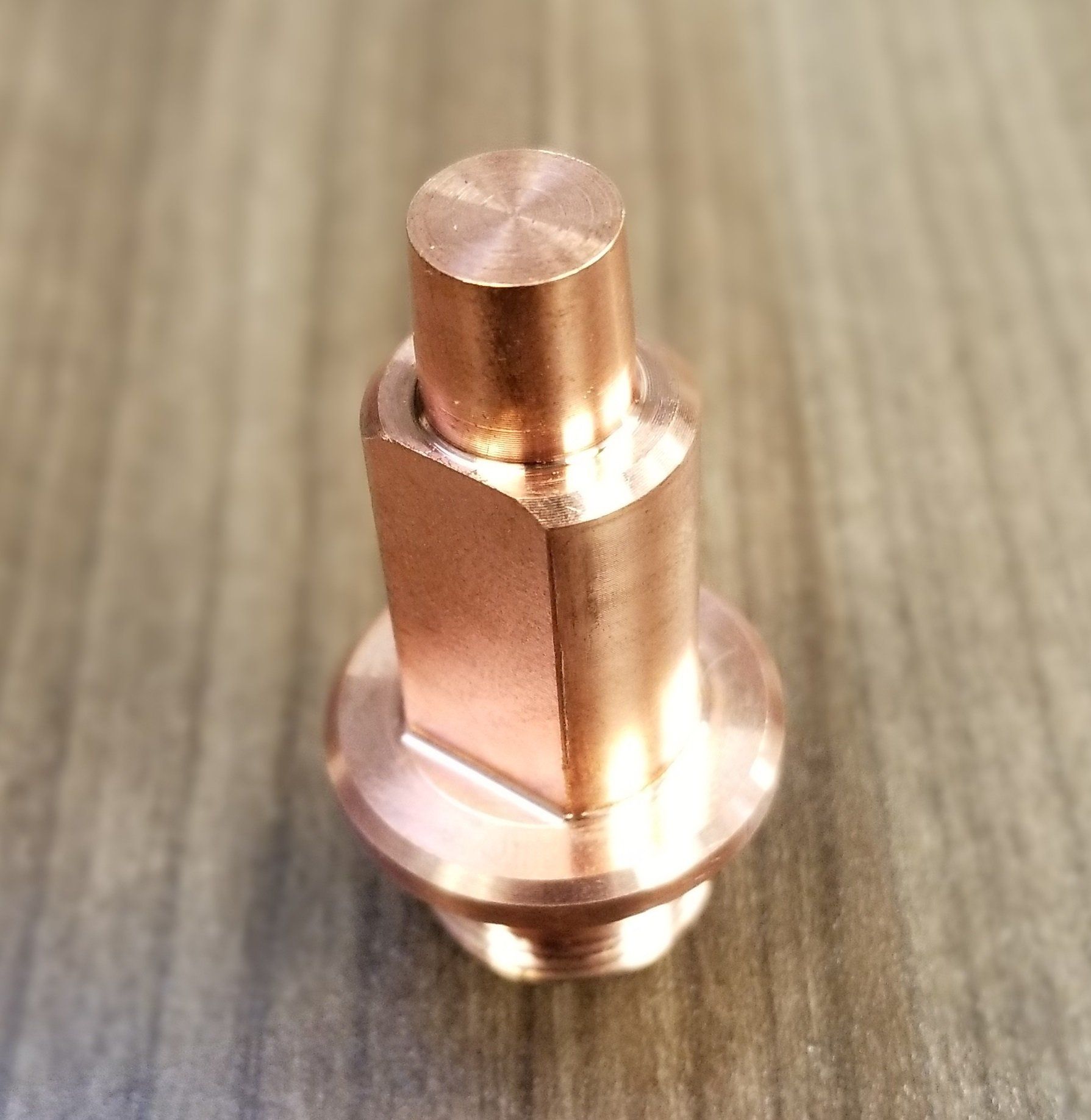 A close up of a copper object on a wooden table.