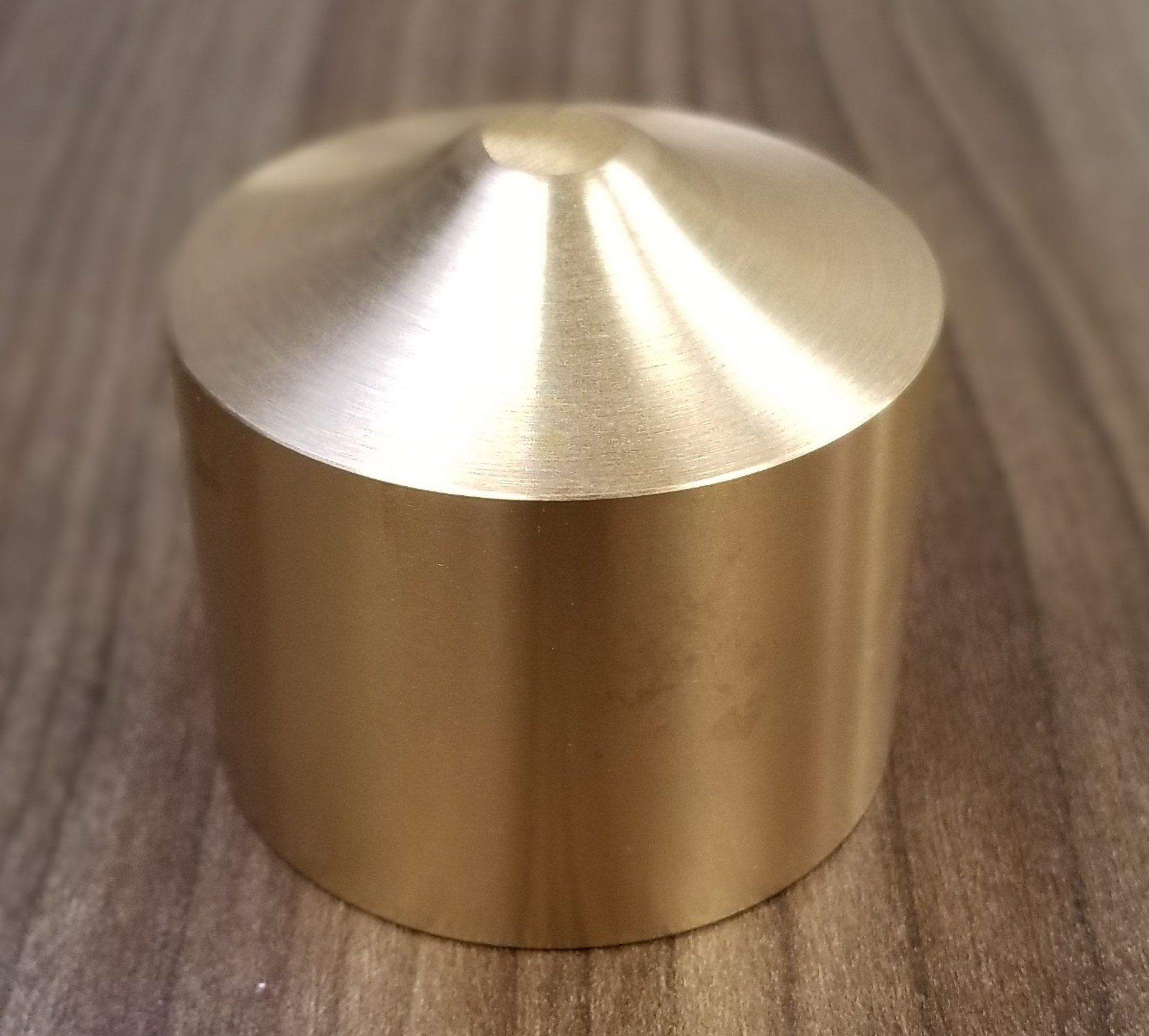 A brass object is sitting on a wooden table