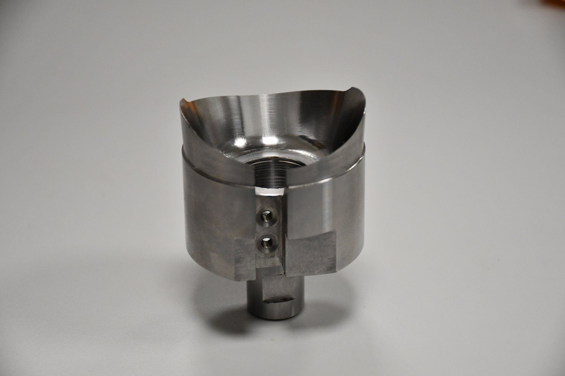 A stainless steel object is sitting on a white surface